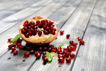 Closeup of ripe pomegranate fruit and seeds on an antique wooden base