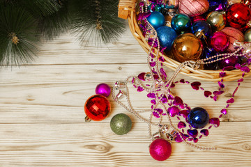 Jewellery chains and balls for the Christmas tree lying in a wicker basket close branches of spruce...