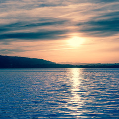 Fantastic evening at the lake. Sun sets behind the horizon.