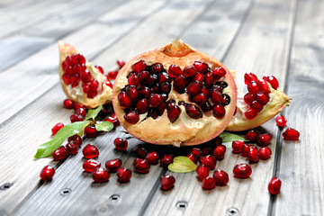 Closeup of ripe pomegranate fruit and seeds on an antique wooden base