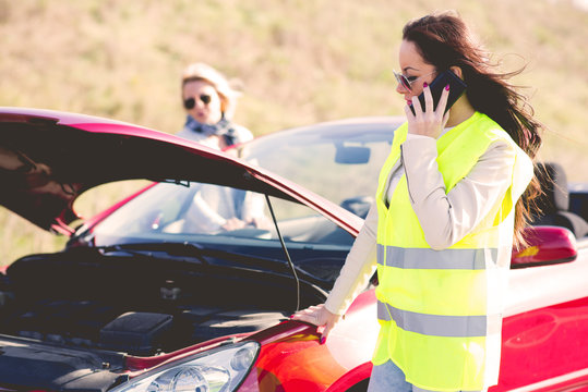 Young woman on the road near a broken car calling for help.Filter colored photo