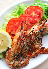 Fresh grilled shrimps with tomatoes, green salad and lemon