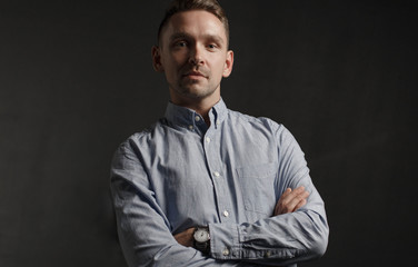 Portrait of young businessman on dark background