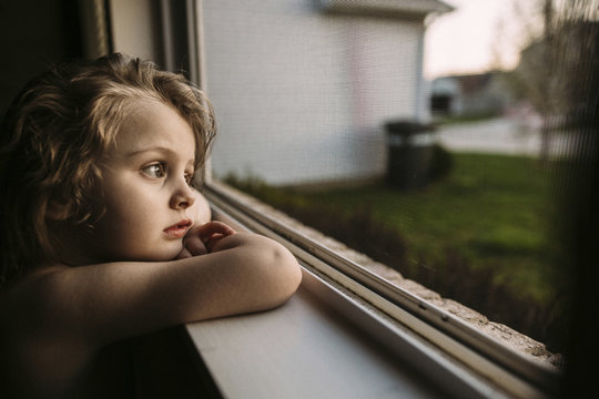 Thoughtful girl looking out through the window