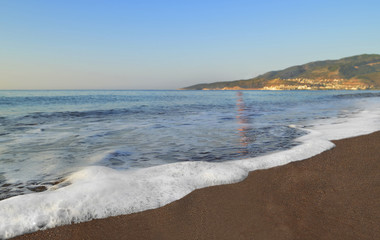 Утренний морской прибой. Пенные волны Средиземного моря омывают песчаный пляж.  Береговая линия.