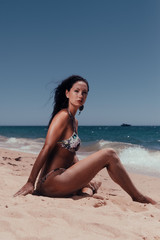Fototapeta na wymiar Beautiful woman in bikini on the sunny beach outdoors background