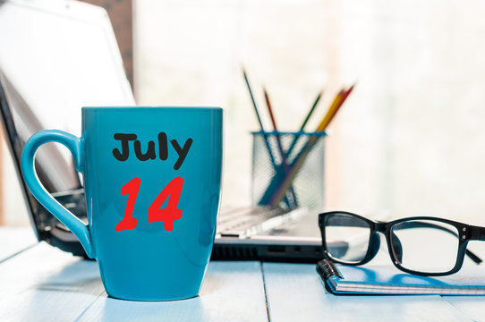 July 14th. Day 14 of month, color calendar on morning coffee cup at business workplace background. Summer concept. Empty space for text