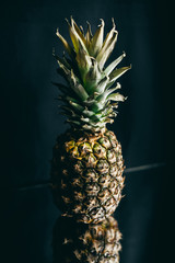 pineapple on a mirror. Black background with copy space