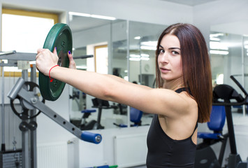 Fototapeta premium Girl is engaged in sports and gymnastics in the gym