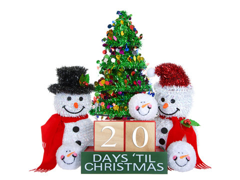 20 Days until Christmas light beech wood blocks with red trim on a green base with tinsel christmas tree, mr and mrs snowman and snowball snowmen heads isolated on a white background.