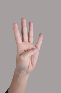 Human armshowing four fingers up.