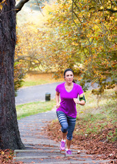 Frau joggt Treppen in einem herbstlichen Park hinauf