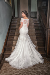Bride going up steps in an elegant bridal gown with train