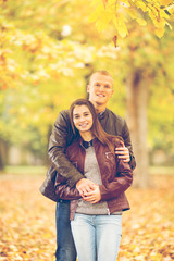 Fototapeta premium Young couple having fun in a park on one beautiful Autumn day.
