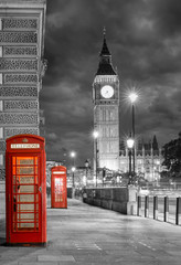 Fototapeta na wymiar Rote Telefonzellen bei Nacht vor dem Big Ben in London mit bewölktem Himmel