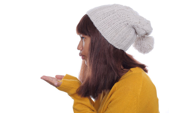 Attraktive junge Frau wirf Handkuss zur Seite und trägt Pullover und Wintermütze