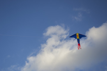 dragon kite flying in a cloudy sky on a bright sunny day