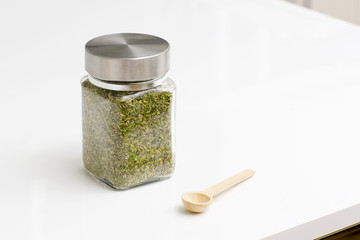Herbs are in the glass jars with spoons. Spice for cooking food on a white background. 