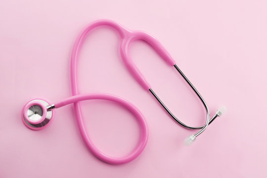 Pink stethoscope on pink background