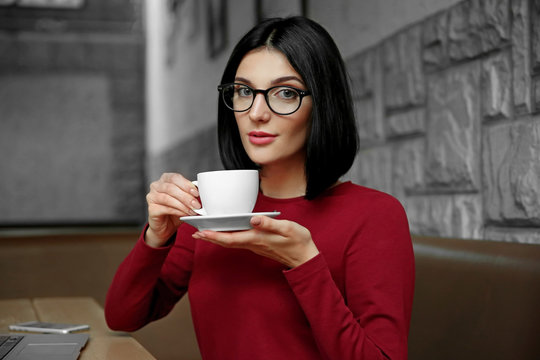 Beautiful young woman drinking coffee at cafe