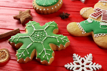 Tasty Christmas cookies and decor on red wooden table, close up view