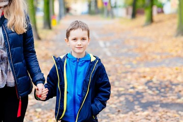 Fototapeta premium Boy holding his mother hand during the walk