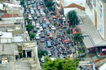 Crowded road traffic seen from top, with many motorcycles parking in side of road, make traffic jam