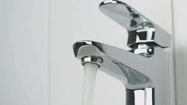 Flow of water is pouring from the stylish faucet