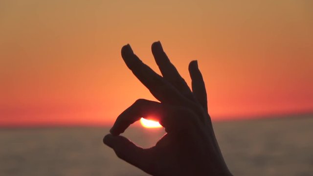 CLOSE UP, DOF: Connecting thumb and forefinger in circle making signal word okay
