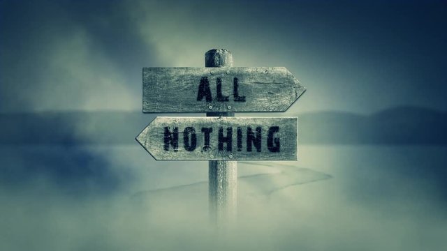 Old Wooden Sign on a Middle of a Cross Road With the Words All or Nothing