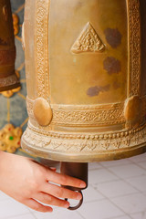 Hand ringing buddhist bell in temple
