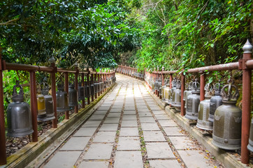 Walkways with many ancient bronze bells on both sides at Phra That Doi Tung Temple.