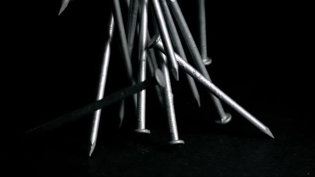 Steel Nails Falling Over Black Background Super Slow Motion