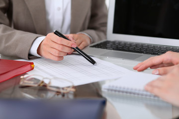 Group of business people at meeting  discussing financial results. Women pointing into laptop computer monitor