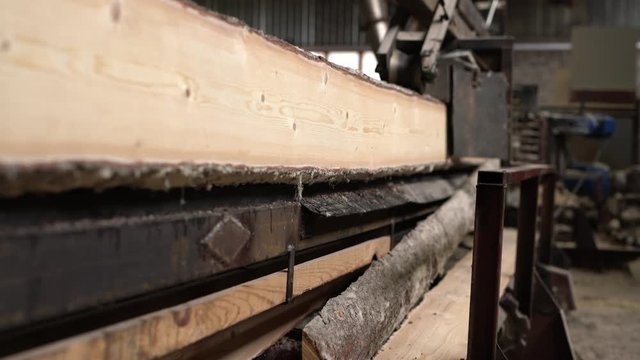 Timber mill. View of log moves with cut to camera