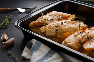 Close-up shot of baked chicken breast with cheese and thyme