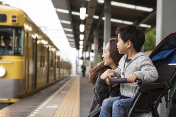 Parents and children are waiting for a train on the platform