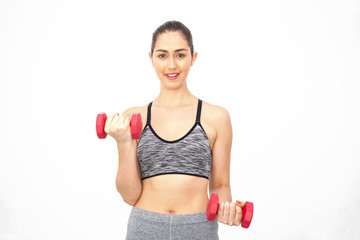 Young Caucasian woman lifting dumbbells over white background - Health and Fitness concept