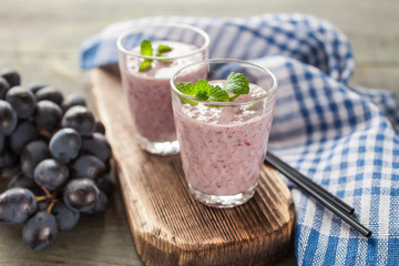 milkshake with banana and grapes in a glass on a table, selective focus