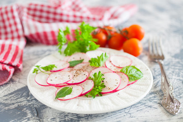 garden radish salad in a plate on a table, selective focus