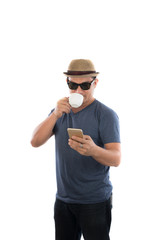 Young hipster man looking at his smart phone and drinking coffee