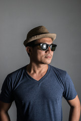 Handsome hipster men wearing hat and glasses posing in studio is