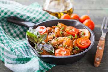 shrimps in tomato sauce with greens on a table, selective focus