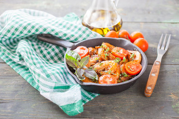 shrimps in tomato sauce with greens on a table, selective focus