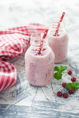 milkshake with a cranberry in bottles on a table, selective focus