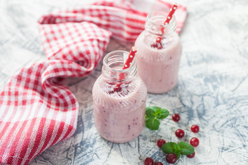 milkshake with a cranberry in bottles on a table, selective focus