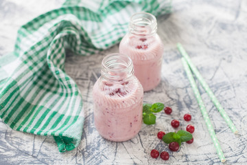 milkshake with a cranberry in bottles on a table, selective focus