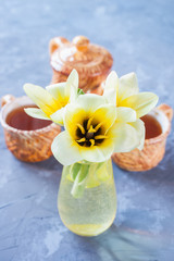 Obraz na płótnie Canvas tulips and tea in a cup on a table, selective focus