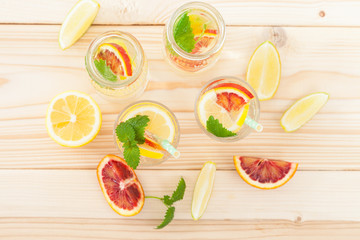 fresh citrus lemonade with mint in a glass on a wooden background, the top view, selective focus