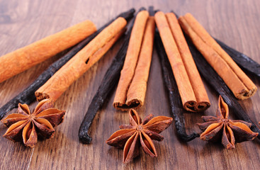 Closeup of star anise, fragrant vanilla and cinnamon on wooden surface plank